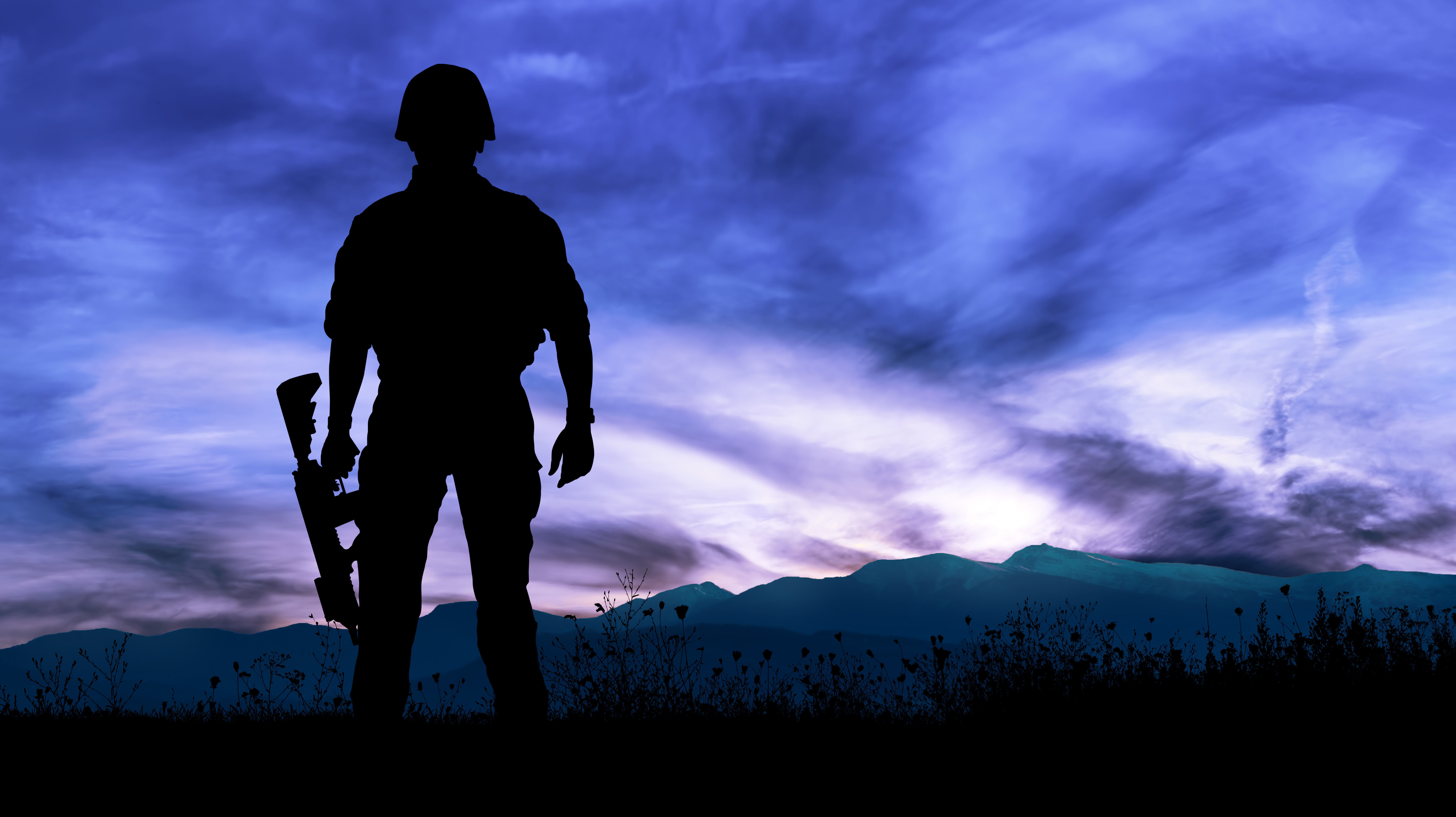 Silhouette of military soldier or officer with weapons at night